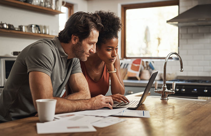 couple in kitchen on laptop banking