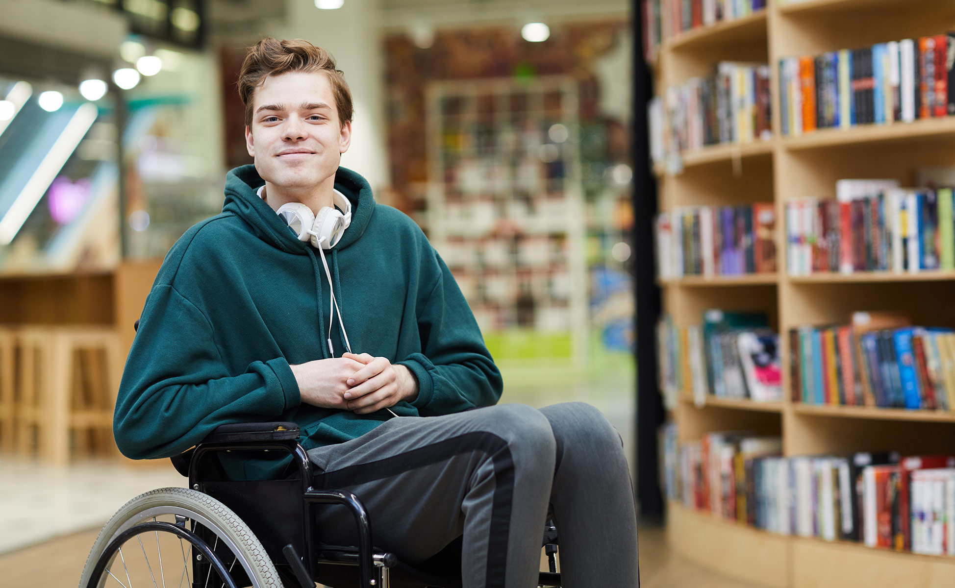 student in a wheelchair in a library