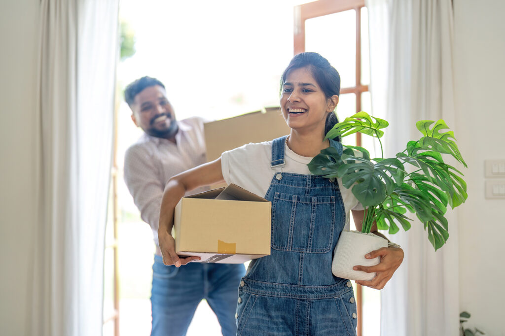 Indian young couple move the box into their new home.
