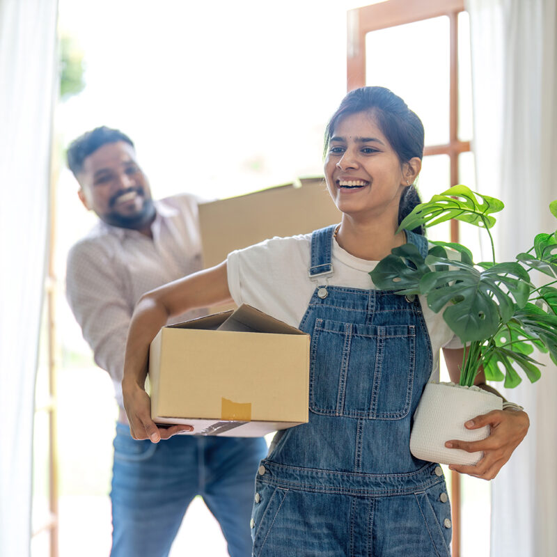 Indian young couple move the box into their new home.