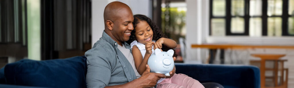 Father and daughter putting away money for the future