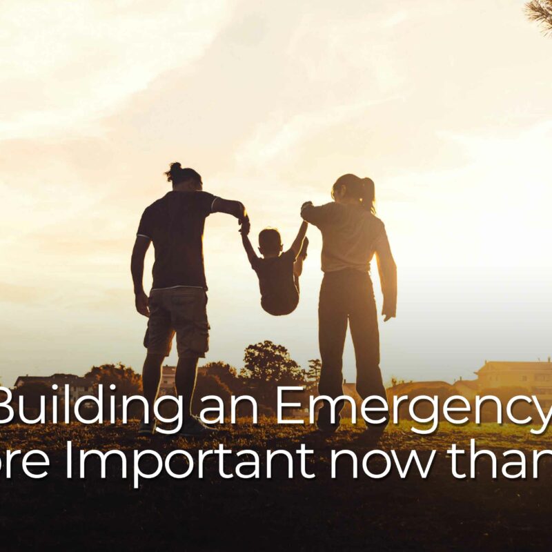 Silhouettes of two adults holding hands with a small child raised between them in an outdoor field at sunset. Large text over the image reads “Why Building an Emergency Fund is more Important now than Ever.”